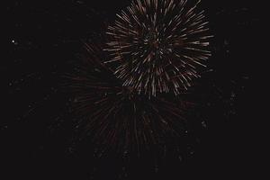 Festive multi-colored pyrotechnics fireworks salute on the dark night sky photo