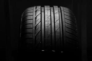 Foto de estudio de neumático de automóvil nuevo aislado sobre un fondo negro