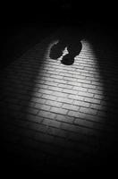 sombras de silueta de una pareja enamorada en un paseo por la ciudad en un día soleado. hombre y mujer tomados de la mano y mirándose, ciudad al aire libre, fotografía en blanco y negro foto