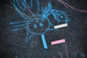 Drawing of cat chalk on the asphalt. Colorful chalk drawing on asphalt, funny cat. photo