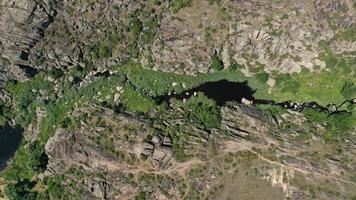 Vista aérea de las texturas y patrones de las rocas y el río de montaña con grietas y verde. foto
