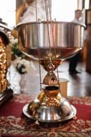 Selective focus. A priest's censer hangs on an old wall in the Orthodox Church. Copper incense with burning coal inside. Service in the concept of the Orthodox Church. Adoration photo