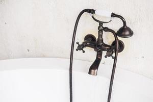 Old vintage faucet on bathtub photo
