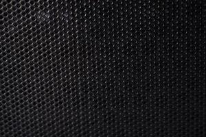 Black background made of iron grating with small round holes photo