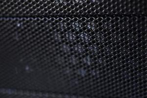 Black background made of iron grating with small round holes photo