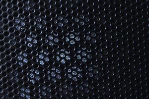 Black background made of iron grating with small round holes photo