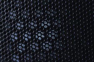 Black background made of iron grating with small round holes photo