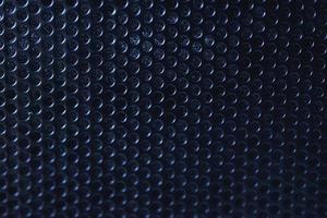 Black background made of iron grating with small round holes photo