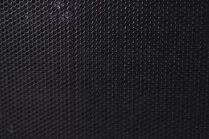 Black background made of iron grating with small round holes photo