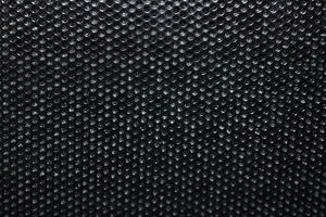 Black background made of iron grating with small round holes photo