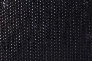 Black background made of iron grating with small round holes photo
