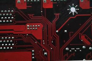 Red computer Motherboard Chips close-up with Contacts photo