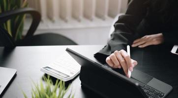 Close-up of a person using a stylus on a tablet computer photo