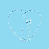 Auriculares con el cable haciendo la forma de un corazón sobre fondo azul, representación 3d foto