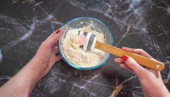 Woman mixing flour in a glass bowl photo