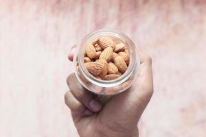 Person holding a jar of almonds photo