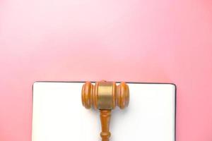 Gavel on paper and pink background photo