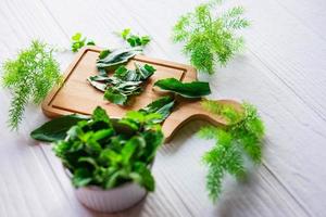 hierbas frescas en una tabla de madera foto