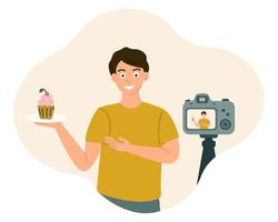 chico blogger de comida sonríe y muestra comida frente a la cámara mientras graba un video, foto