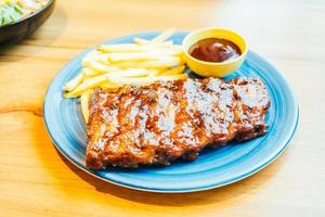 BBQ a la parrilla o costilla a la barbacoa con papas fritas foto