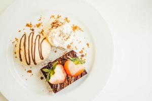 Vanilla ice cream with chocolate brownie cake with strawberry on top photo