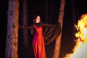 Girl alone at night in the forest brews a potion and wonders for marriage photo