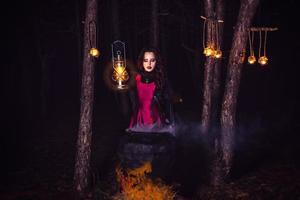 Girl alone at night in the forest brews a potion and wonders for marriage photo