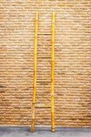 Wood ladder on brick wall background photo