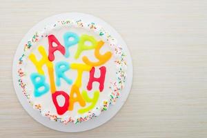 Happy birthday cake on wooden background photo