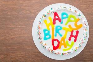 Happy birthday cake on wooden background photo