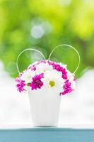 Boquet of flower in vase with outdoor view background photo