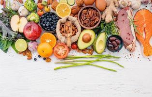 Ingredientes para la selección de alimentos saludables sobre fondo blanco de madera