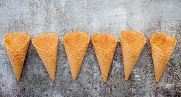 Colección de conos de helado planos laicos sobre fondo de piedra oscura foto