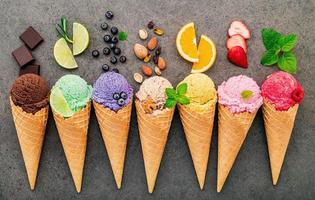 Colección de conos de helado planos laicos sobre fondo de piedra oscura foto