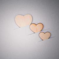 Wooden hearts on cardboard background photo