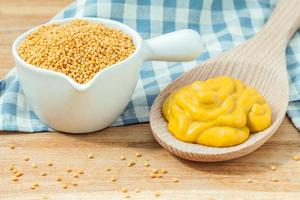 Composition of mustard and mustard seeds on wooden background photo