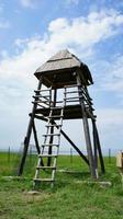 Torre de madera en un campo con nublado cielo azul en Taman, Rusia foto