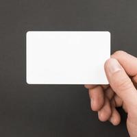 Hand holding business card on gray background