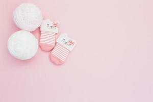 Cute tiny wool socks on pink background photo