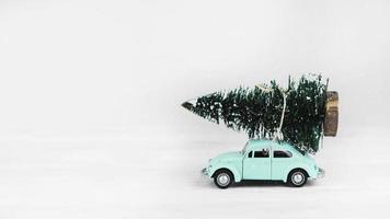 Car toy with fir tree on top on white background photo