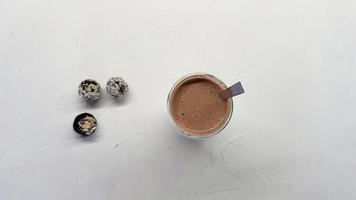 xícara de chocolate quente e três bombons de chocolate na mesa video