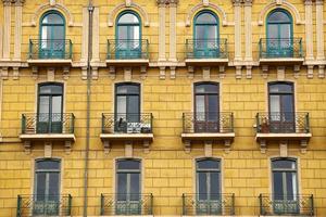 Ventana en la fachada amarilla de la casa, arquitectura en la ciudad de Bilbao, España foto