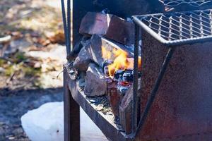 Fuego en una parrilla vintage oxidada al aire libre con fondo borroso foto