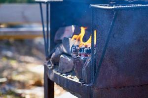 Fire in a rusty vintage grill outdoor with blurred background photo