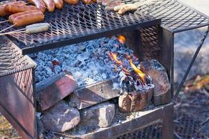 Fuego en una parrilla vintage oxidada al aire libre con fondo borroso foto