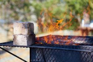 Fire in a rusty vintage grill outdoor on the beach of the sea photo