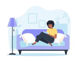 Young woman sitting at home on the sofa and reading a book vector