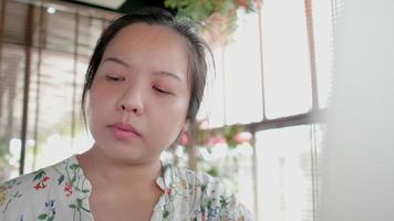 närbild frilansare asiatisk kvinna äta tårta och använda bärbar dator i kafé video