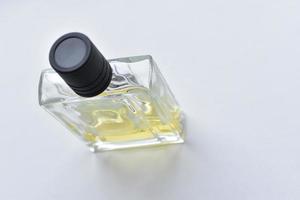 Frasco de perfume de vidrio cuadrado sobre fondo blanco. foto