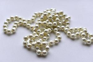 White pearl necklace beads on white background photo